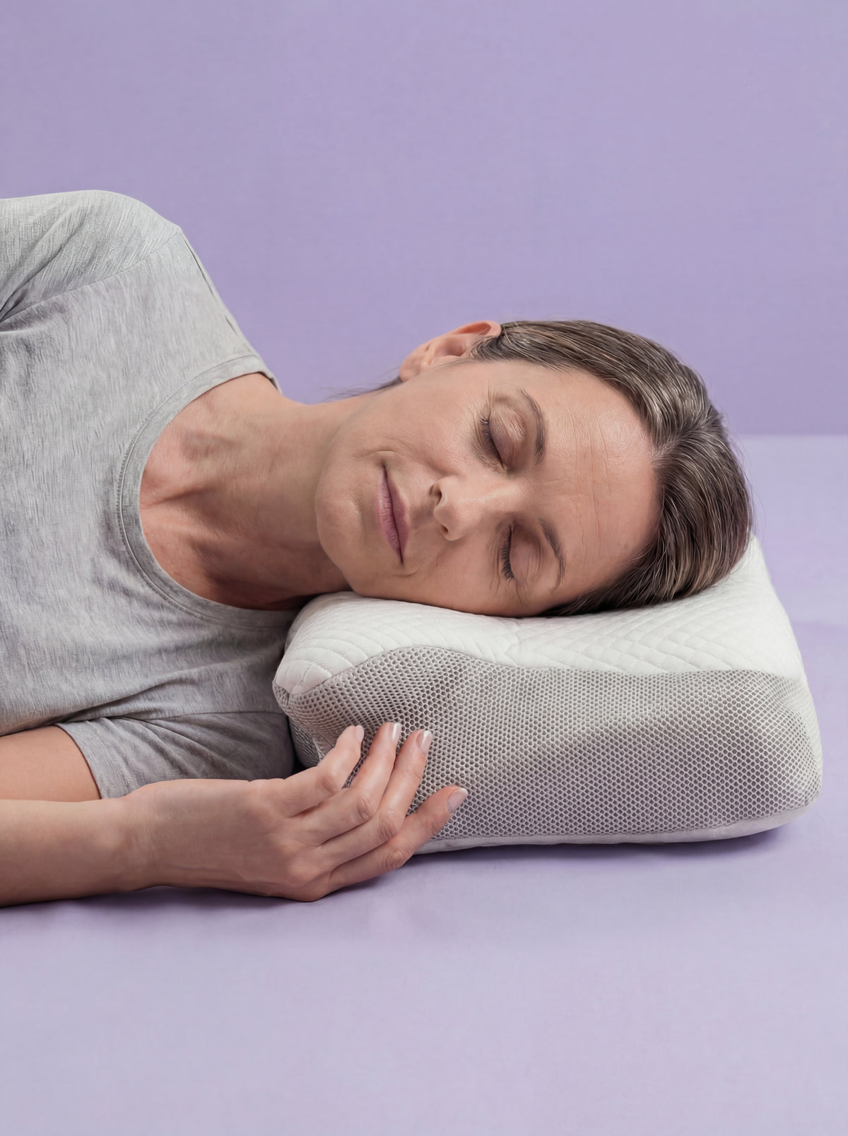Mujer durmiendo de lado sobre la almohada ergonómica