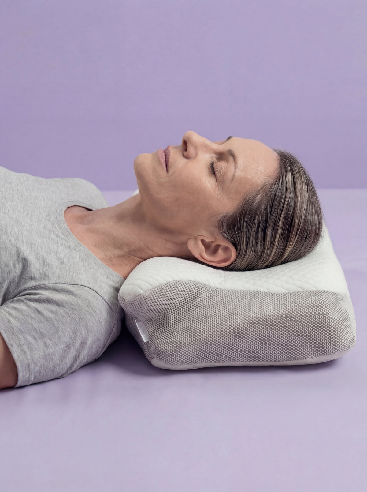 Mujer durmiendo boca arriba sobre la almohada ergonómica